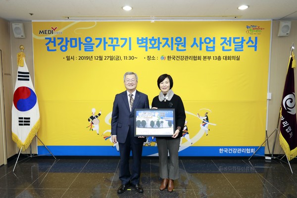 채종일 회장(왼쪽)이 박남희 도시재생과장에 동래구일대에 지원한 벽화 사진이 담긴 액자를 전달했다.