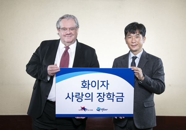 오동욱 사장(오른쪽)이 제프리 존스 이사장에게 ‘화이자 사랑의 장학금’을 전달하고 있다.